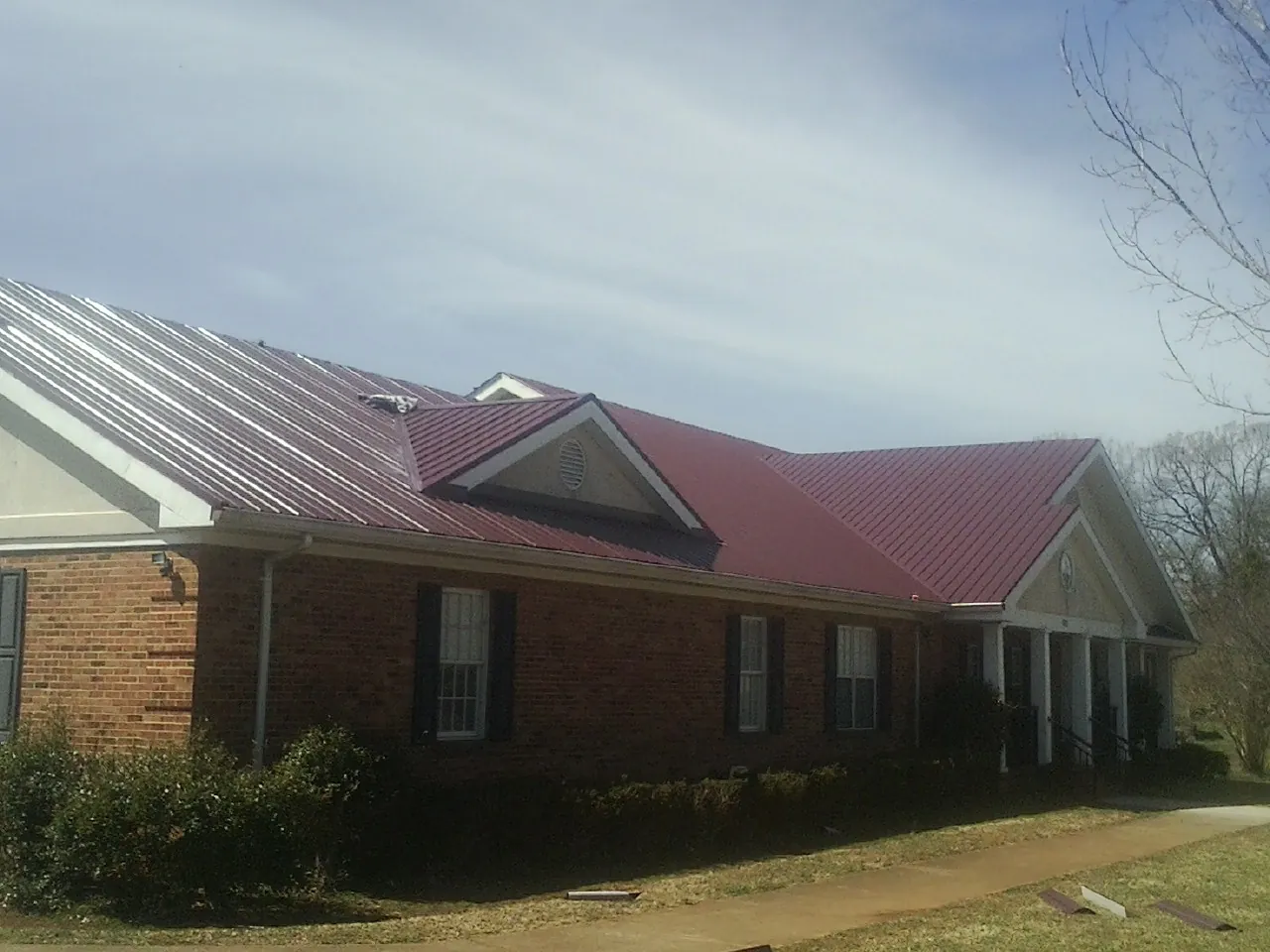 Red metal roof with gabled entries on a long brick building in Stephens City