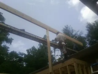 Carpenter setting a ridge beam over a new addition frame — Ice Dam Removal by Roofing Brothers in Stephens City