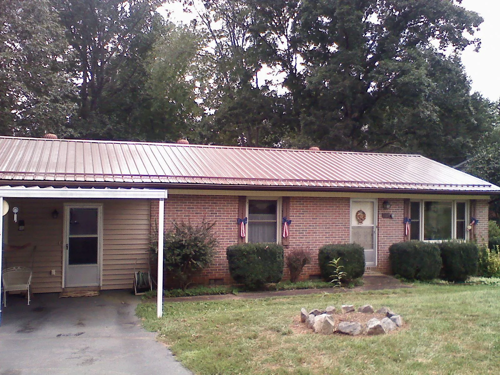 Bronze metal roof and carport on a brick ranch home — Roof Repair work by our crew in Stephens City